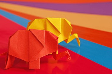 Origami fil var. Kağıt fil renkli bir arka plan üzerinde. Japon sanatı.
