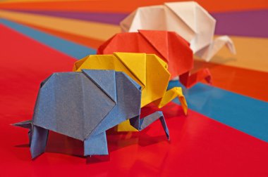 Origami fil. Çok renkli bir arka plan üzerinde renkli kağıt filler. Japon sanatı.