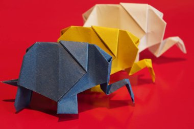 Origami fil. Çok renkli bir arka plan üzerinde renkli kağıt filler. Japon sanatı.
