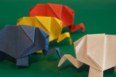 Beyaz origami fil. Çok renkli bir arka plan üzerinde renkli kağıt filler. Japon sanatı.
