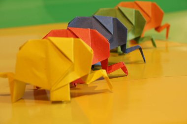 Origami fil. Çok renkli bir arka plan üzerinde renkli kağıt filler. Japon sanatı.