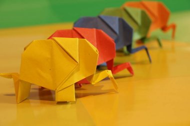 Origami fil. Çok renkli bir arka plan üzerinde renkli kağıt filler. Japon sanatı.