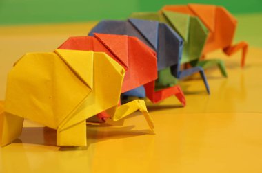 Origami fil. Çok renkli bir arka plan üzerinde renkli kağıt filler. Japon sanatı.