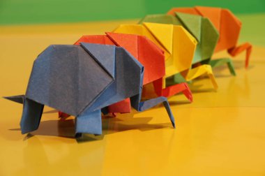 Origami fil. Çok renkli bir arka plan üzerinde renkli kağıt filler. Japon sanatı.