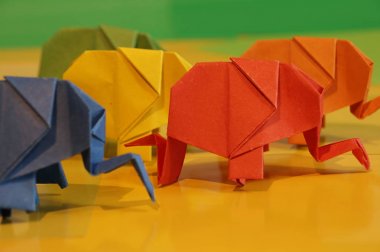 Origami fil. Çok renkli bir arka plan üzerinde renkli kağıt filler. Japon sanatı.