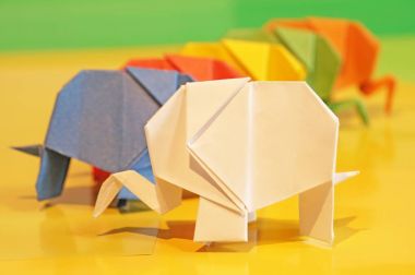 Origami fil. Çok renkli bir arka plan üzerinde renkli kağıt filler. Japon sanatı.