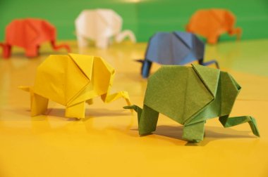 Origami fil. Çok renkli bir arka plan üzerinde renkli kağıt filler. Japon sanatı.