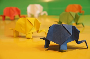 Origami fil. Çok renkli bir arka plan üzerinde renkli kağıt filler. Japon sanatı.