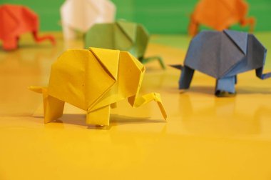 Origami fil. Çok renkli bir arka plan üzerinde renkli kağıt filler. Japon sanatı.