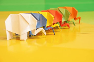 Origami fil. Çok renkli bir arka plan üzerinde renkli kağıt filler. Japon sanatı.