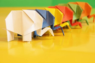 Origami fil. Çok renkli bir arka plan üzerinde renkli kağıt filler. Japon sanatı.