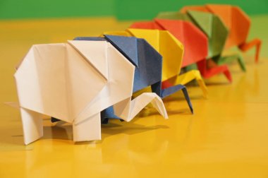 Origami fil. Çok renkli bir arka plan üzerinde renkli kağıt filler. Japon sanatı.
