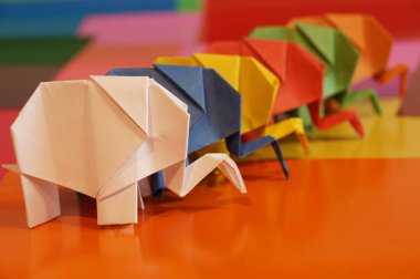 Origami fil. Çok renkli bir arka plan üzerinde renkli kağıt filler. Japon sanatı.