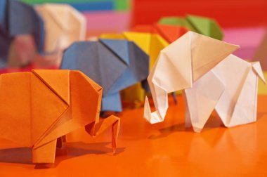 Beyaz origami fil. Çok renkli bir arka plan üzerinde renkli kağıt filler. Japon sanatı.