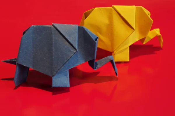 Origami is the elephant. Paper elephant on a colored background. Japanese art.