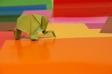 Origami fil var. Kağıt fil renkli bir arka plan üzerinde. Japon sanatı.