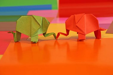 Origami fil var. Kağıt fil renkli bir arka plan üzerinde. Japon sanatı.