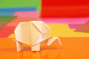 Origami fil var. Kağıt fil renkli bir arka plan üzerinde. Japon sanatı.