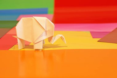 Origami fil var. Kağıt fil renkli bir arka plan üzerinde. Japon sanatı.