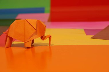 Origami fil var. Kağıt fil renkli bir arka plan üzerinde. Japon sanatı.