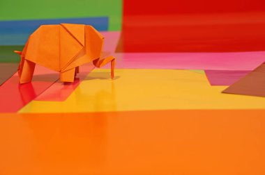 Origami fil var. Kağıt fil renkli bir arka plan üzerinde. Japon sanatı.