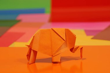 Origami fil var. Kağıt fil renkli bir arka plan üzerinde. Japon sanatı.