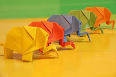 Origami fil. Çok renkli bir arka plan üzerinde renkli kağıt filler. Japon sanatı.