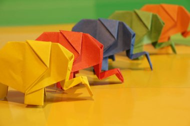 Origami fil. Çok renkli bir arka plan üzerinde renkli kağıt filler. Japon sanatı.