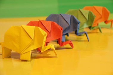 Origami fil. Çok renkli bir arka plan üzerinde renkli kağıt filler. Japon sanatı.