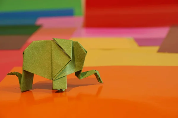 Origami is the elephant. Paper elephant on a colored background. Japanese art.