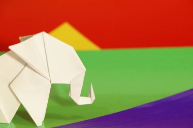 Beyaz origami fil. Renkli bir arka plan üzerinde beyaz kağıt fil. Japon sanatı.