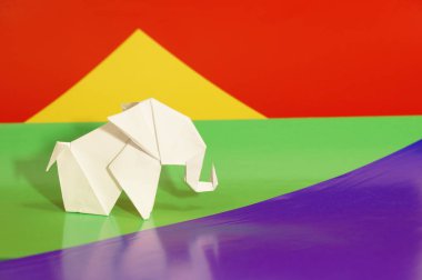 Beyaz origami fil. Renkli bir arka plan üzerinde beyaz kağıt fil. Japon sanatı.