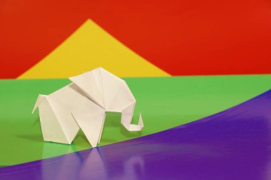 Beyaz origami fil. Renkli bir arka plan üzerinde beyaz kağıt fil. Japon sanatı.
