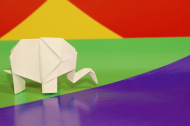Beyaz origami fil. Renkli bir arka plan üzerinde beyaz kağıt fil. Japon sanatı.