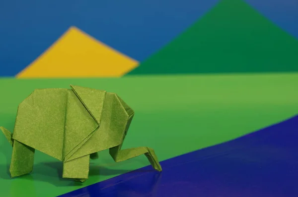 Origami is the elephant. Paper elephant on a colored background. Japanese art.