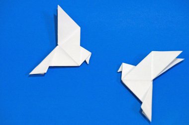 Origami güvercinler üzerinde mavi arka plan izole.