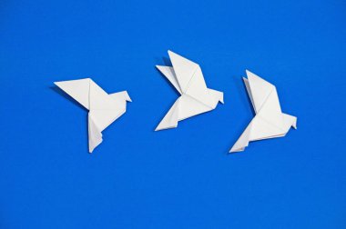 Origami güvercinler üzerinde mavi arka plan izole.