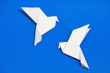 Origami güvercinler üzerinde mavi arka plan izole.