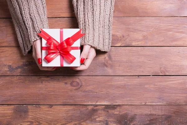 Frau hält Weihnachtsgeschenk in der Hand — Stockfoto