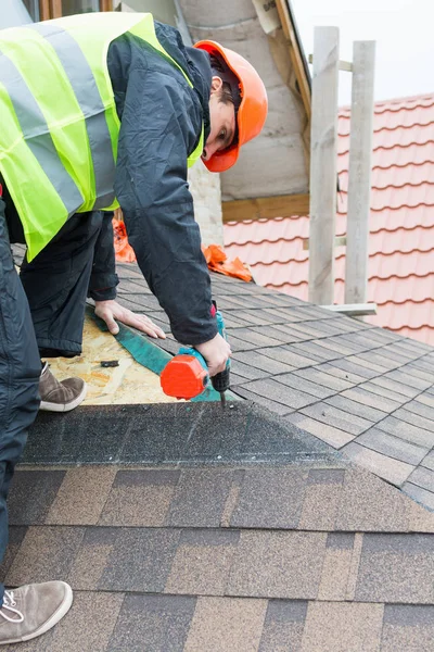 Worker dismantling roof shingles — Stock Photo, Image