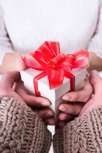 Frau hält Weihnachtsgeschenk in der Hand — Stockfoto