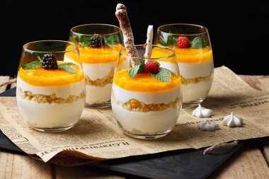 Eski ahşap zemin üzerine bardaklarda portakal cheesecake