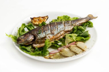 Beyaz zemin üzerine sebzeli ızgara balık