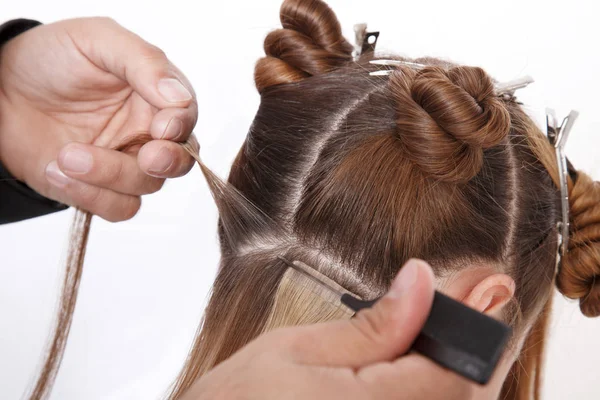 Extensiones de cabello natural en el salón, manos de cerca en el cabello —  Fotos de Stock