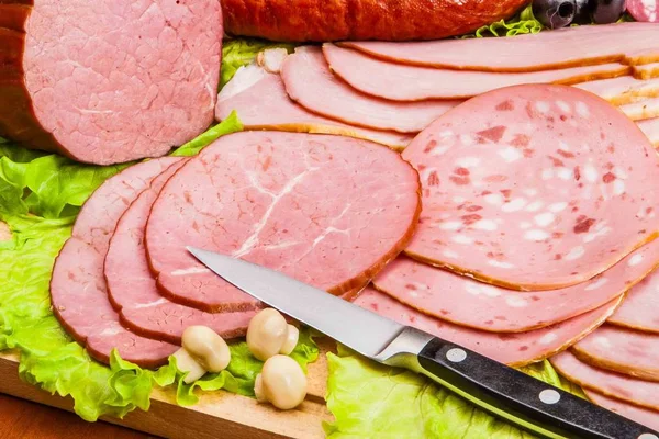 Köttprodukter på en träskiva — Stockfoto
