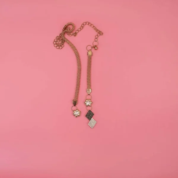 ピンクの背景に隔離された黄金のネックレス — ストック写真
