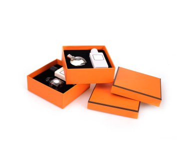 Beyaz arka planda izole edilmiş kırmızı kutulardaki parfüm şişeleri.