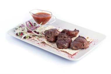 Kuzu şiş kebap, taze sebze ve kırmızı soslu menü ve ağ için beyaz tabakta.