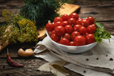 Koyu renkli ahşap bir masada turşular, hafif tekstil ve tahta kesim.