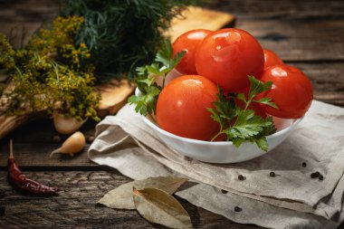 Koyu renkli ahşap bir masada turşular, hafif tekstil ve tahta kesim.